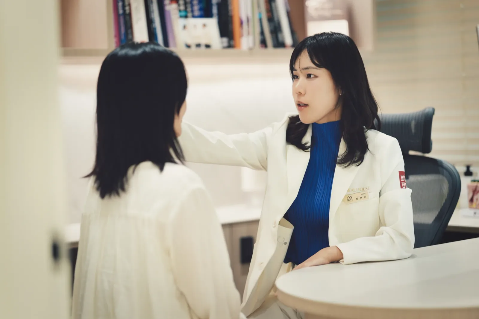 진료실에서 고객의 얼굴을 살피며 눈을 맞추고 상담하는 힐하우스피부과 피부과 전문의